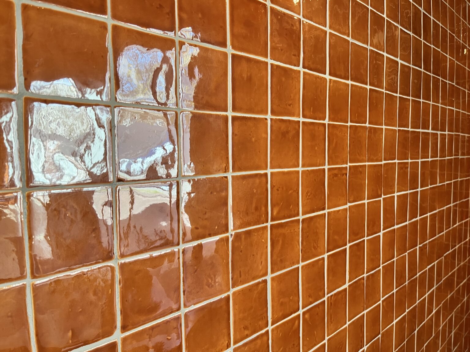 De terracottakleurige tegelwand in de brasserie